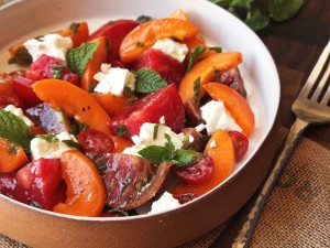 A bowl of fruit salad with feta cheese.