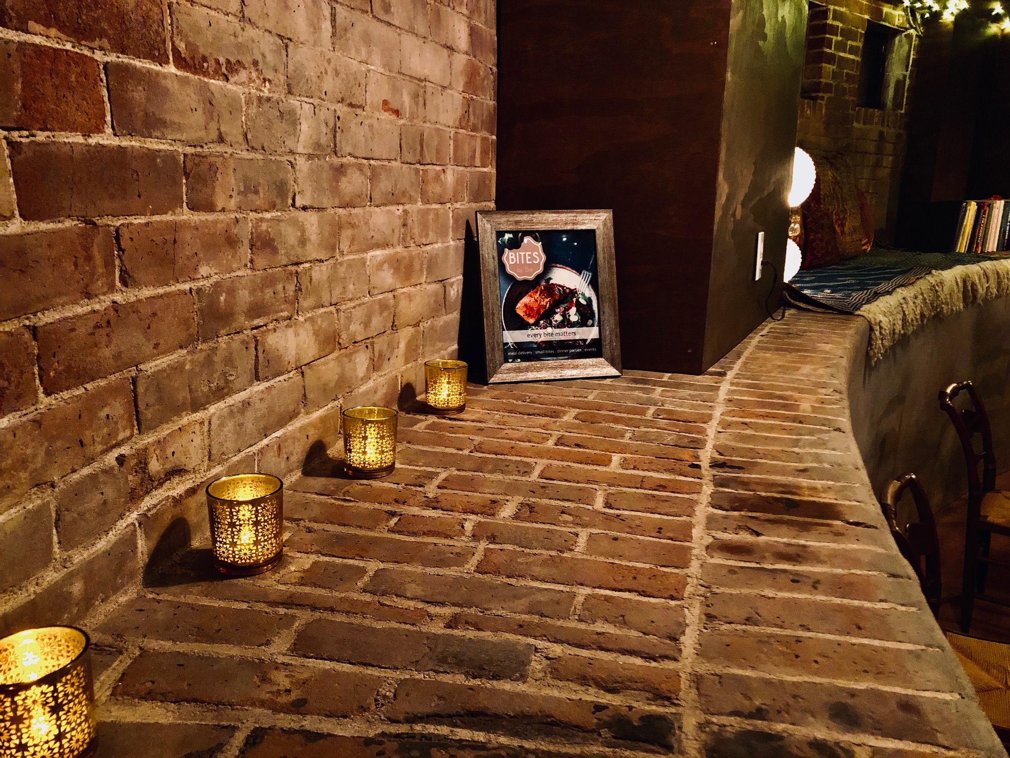 A brick walkway with candles and a picture of a person.